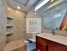 Modern bathroom with large mirror, wood accents, and walk-in shower.