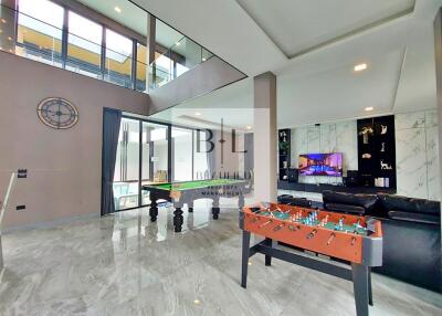 Spacious living area with large windows, pool table, and modern furnishings