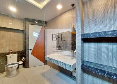 Modern bathroom with tiled walls and a large mirror