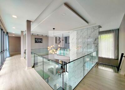 Modern interior with glass railing and chandelier