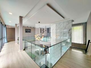 Modern interior with glass railing and chandelier