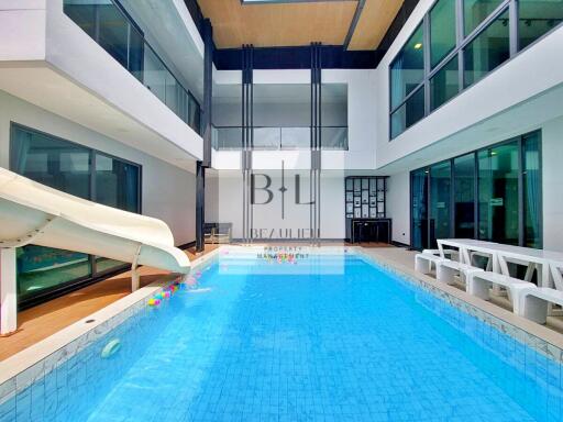 Indoor pool area with a slide and seating