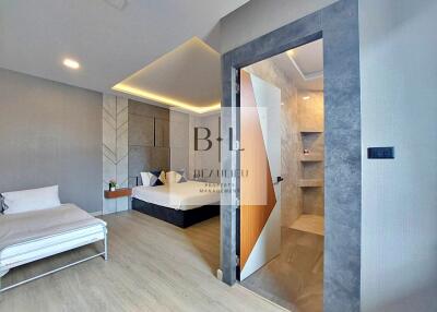 Modern bedroom with bed, sofa bed, and ensuite bathroom