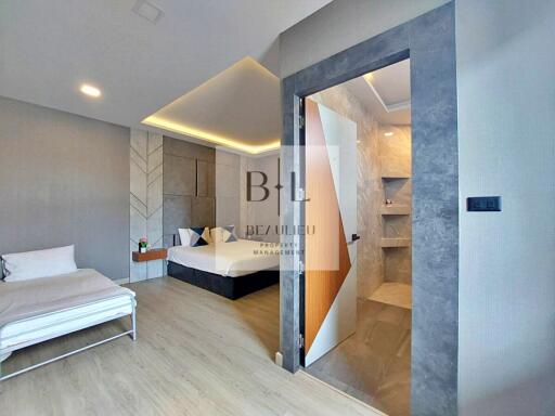 Modern bedroom with bed, sofa bed, and ensuite bathroom