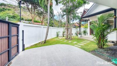 Well-maintained outdoor garden with tiled patio and pathway