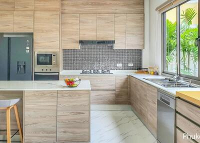 Modern kitchen with wooden cabinetry, island with seating, and large window