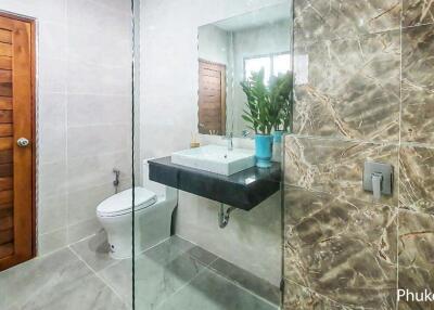 Modern bathroom with wooden door and marble wall