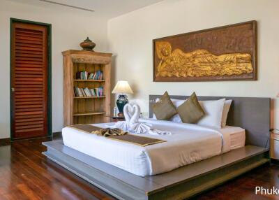 Spacious bedroom with a large bed, wooden flooring, and stylish decor