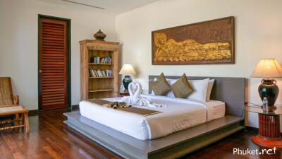 Spacious bedroom with a large bed, wooden flooring, and stylish decor