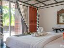 Bright bedroom with large glass doors leading to a balcony, featuring a neatly made bed