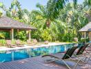 Beautiful tropical outdoor pool with sun loungers and gazebos