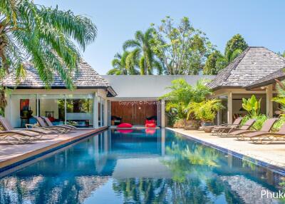 Luxurious poolside area with loungers and tropical landscaping