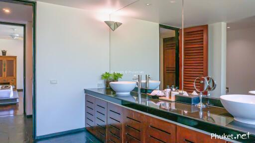 Modern bathroom with dual sinks, large mirror, and sleek design