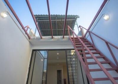 Outdoor staircase to the upper level with ceiling and lights