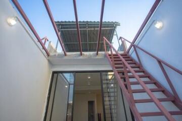 Outdoor staircase to the upper level with ceiling and lights