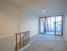 A spacious living area with large sliding glass doors leading to an exterior staircase and balcony