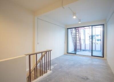 Spacious living room with large windows and staircase