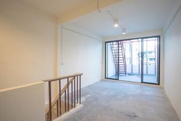 Spacious living room with large windows and staircase