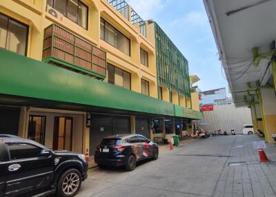 Exterior view of a multi-story commercial building with parked cars