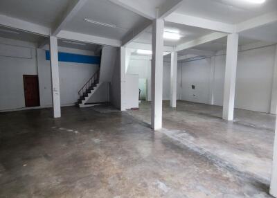 Spacious empty interior with concrete floor and staircase
