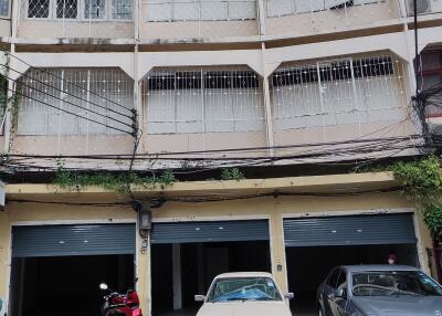 Exterior view of a multi-level apartment building with parking spaces