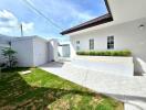 Outdoor area with landscaped lawn and paved walkway