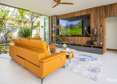 Modern living room with large TV, orange sofa, and garden view