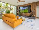 Modern living room with large TV, orange sofa, and garden view