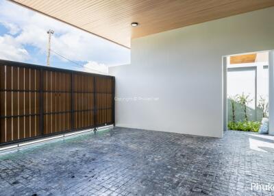 Outdoor parking area with gate and partial view of garden