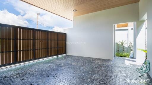 Outdoor parking area with gate and partial view of garden