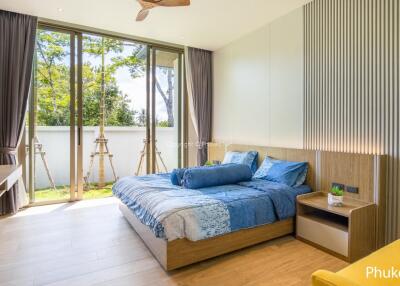 Bright modern bedroom with large windows, bed, and seating area