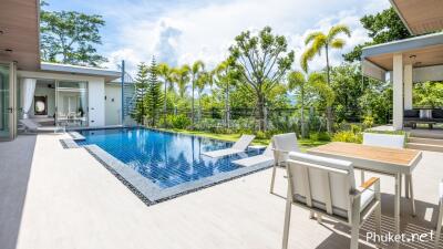 A beautiful outdoor area with a swimming pool, lounge chairs, and outdoor seating.