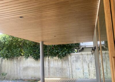 Covered outdoor patio with wooden ceiling and deck