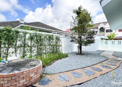 Beautifully landscaped backyard garden with gravel path and tree