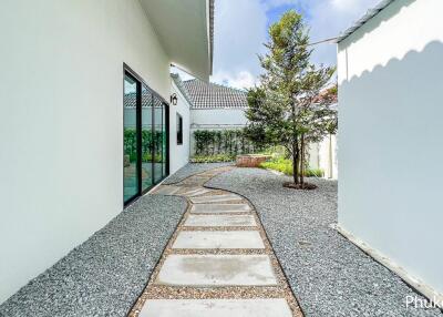 Modern exterior walkway in a property with greenery and large glass windows