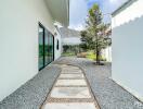 Modern exterior walkway in a property with greenery and large glass windows