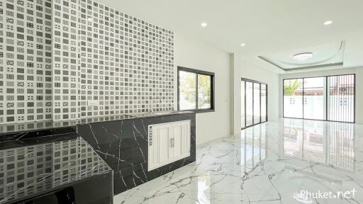 Spacious modern living area with marble flooring and patterned accent wall