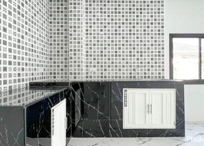 Modern kitchen with black countertops and patterned tile backsplash