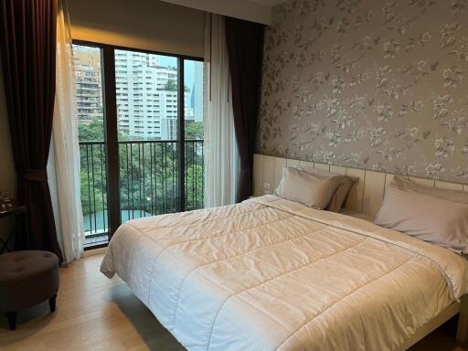 Bedroom with large bed, floral wallpaper, and balcony view