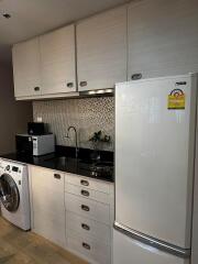 Modern kitchen with white cabinets, black granite countertop, and appliances