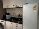 Modern kitchen with white cabinets, black granite countertop, and appliances