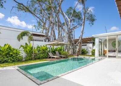 Outdoor pool area with lounge chairs and lush greenery