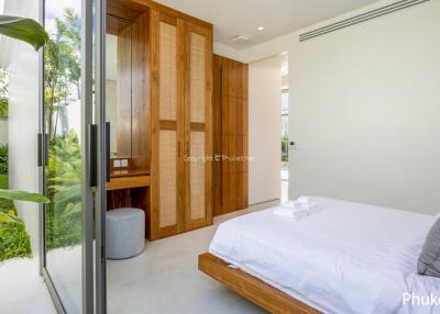 Bright bedroom with large glass doors leading to a garden