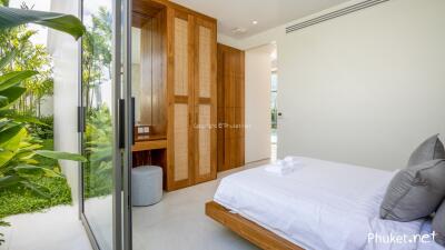 Bright bedroom with large glass doors leading to a garden