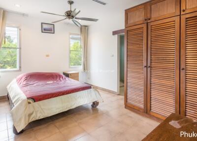 Spacious bedroom with large windows and wooden wardrobe