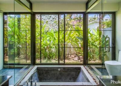 Spacious bathroom with large windows and garden view