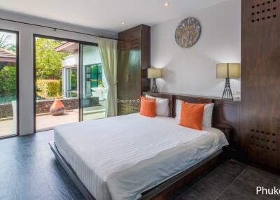 Spacious bedroom with large glass doors opening to outdoor pool area