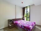 Modern bedroom with large window and colorful bedspread