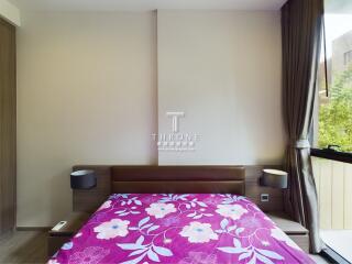 Bedroom with a floral-patterned bedspread and bedside lamps