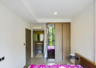 A spacious bedroom with floral bedding and large wardrobe